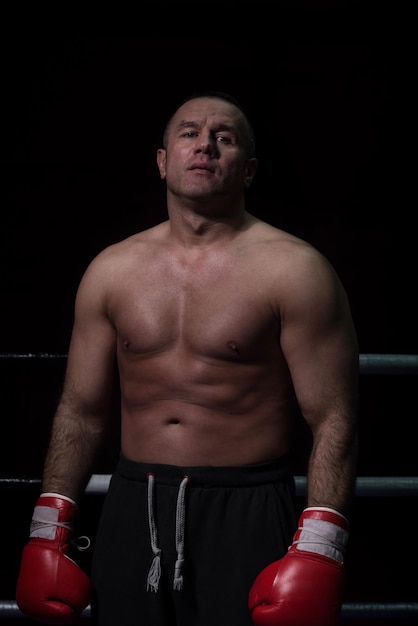 retrato de kickboxer profissional musculoso que está no ringue enquanto treina para a luta