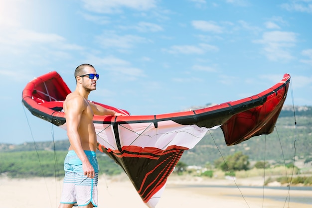 Retrato de kitesurfer de homem bonito na praia.