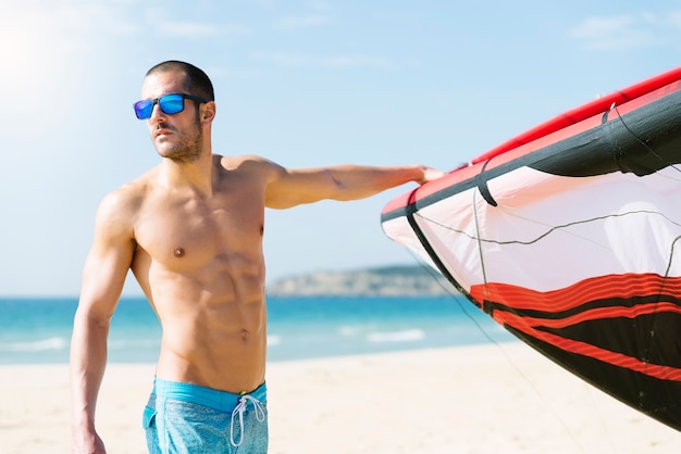 Retrato de kitesurfer de homem bonito na praia.