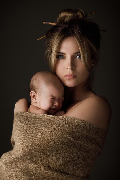 Retrato de linda mãe e seu bebê estão embrulhados em pano de saco