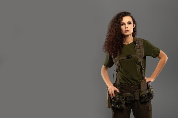 Foto retrato de linda morena encaracolada com expressão séria no rosto do soldado feminino