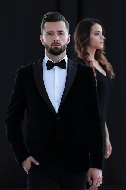 Retrato de lindo casal sensual em roupas elegantes posando isolado em preto