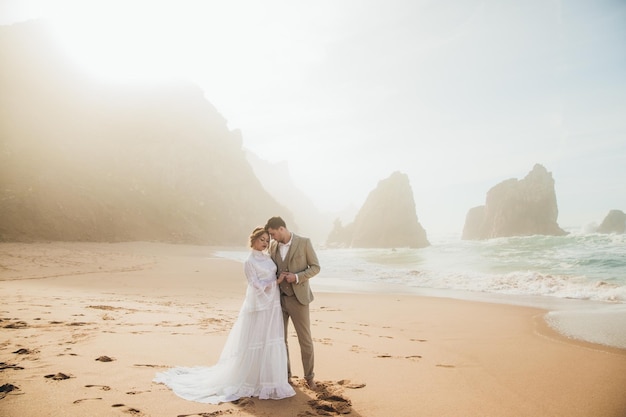 Retrato de lindo jovem casal de noivos na praia