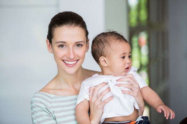 Retrato de mãe alegre carregando bebê