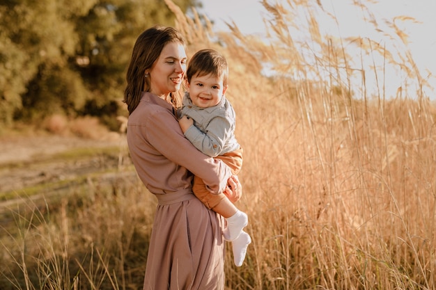 Retrato de mãe amorosa feliz e filho bebê ao ar livre.