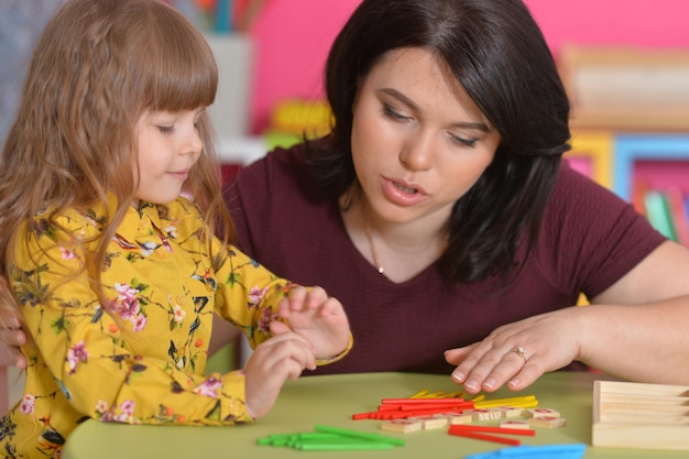 Foto retrato de mãe com filha contando com paus