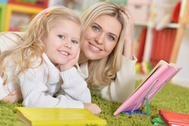 Retrato de mãe com filha lendo livro