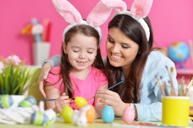 Retrato de mãe e filha decorando ovos de Páscoa