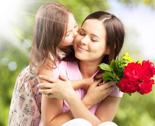 Foto retrato de mãe e filha felizes segurando flores