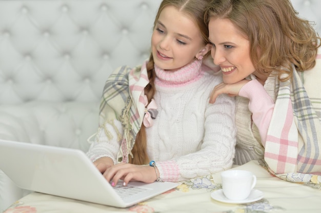 Retrato de mãe e filha usando laptop juntos