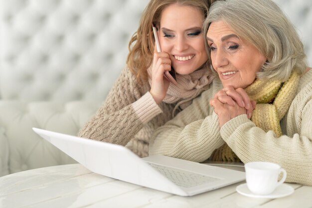 Retrato de mãe e filha usando laptop, sorrindo