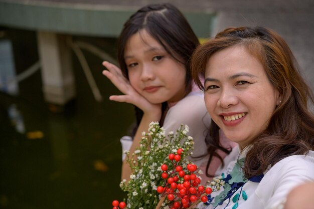 Retrato de mãe e filha vietnamitas em ao dai vestido tradicional vietnamita ao ar livre