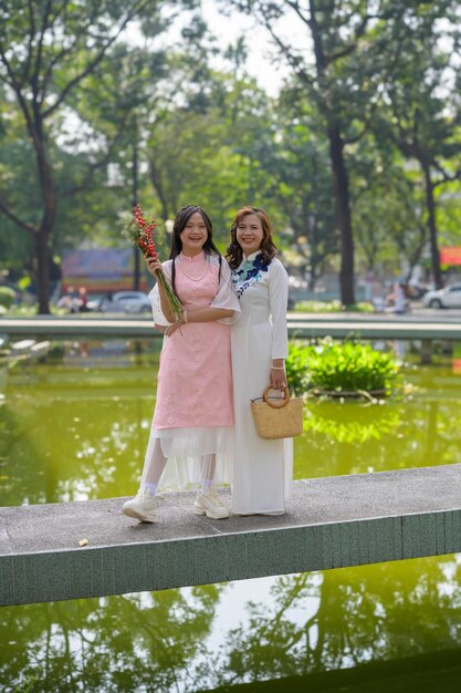 Retrato de mãe e filha vietnamitas em ao dai vestido tradicional vietnamita ao ar livre