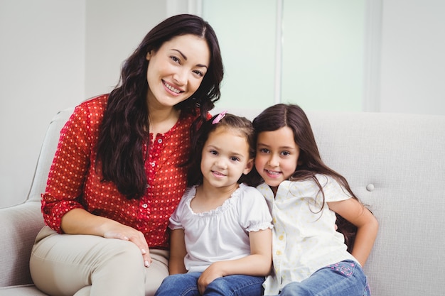 Retrato de mãe e filhas a sorrir em casa