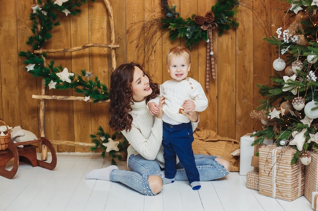 Retrato de mãe e filho felizes ao lado da árvore de Natal