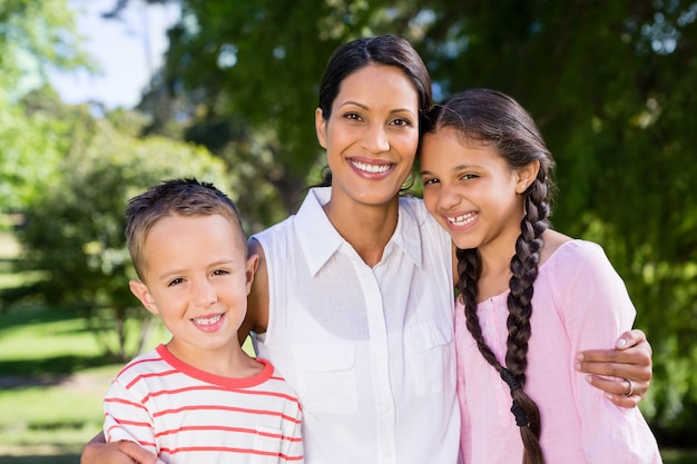 Retrato de mãe em pé com os filhos no parque