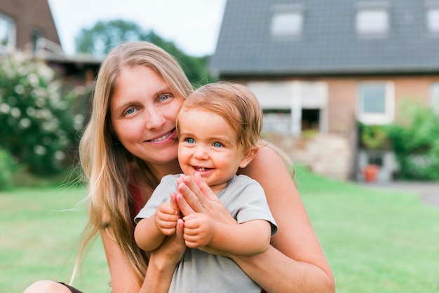 Foto retrato de mãe feliz com filha contra a casa