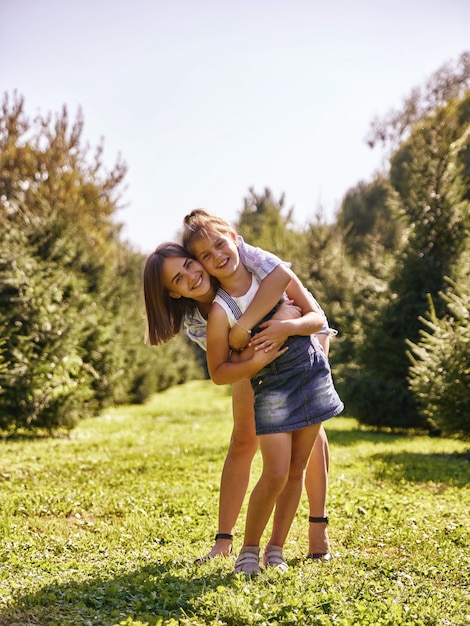 Retrato de mãe feliz e menina abraçando no parque