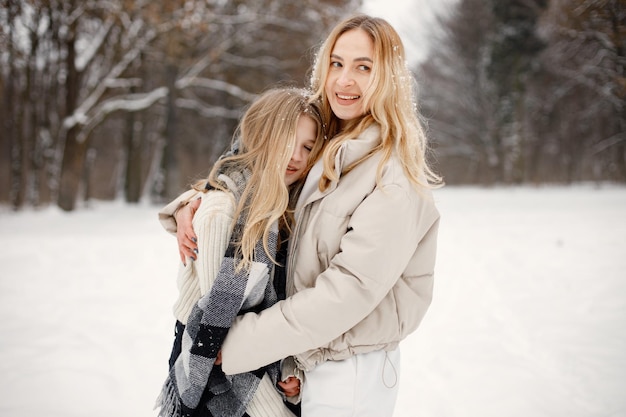 Retrato de mãe loira e filha adolescente em pé na floresta de inverno