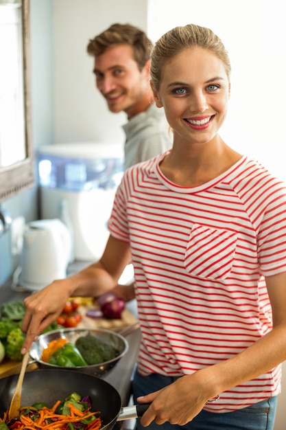 Retrato de marido e mulher a cozinhar comida em casa