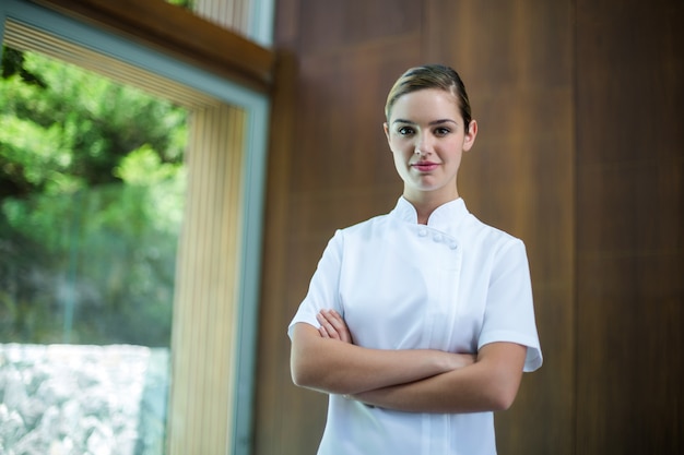 Retrato de massagista feminina confiante em pé com os braços cruzados