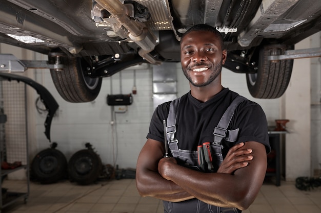 Retrato de mecânico de automóveis em uniforme posando depois do trabalho