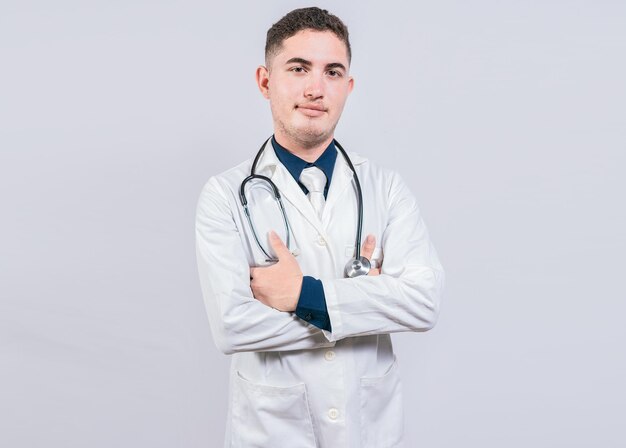 Retrato de médico bonito com braços cruzados médico latino isolado com braços cruzados em fundo branco