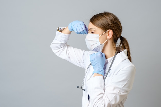 Retrato de médico colocando máscara estéril isolada em cinza