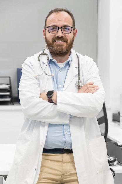 Retrato de médico confiante cruzando as mãos e sorrindo para a câmera