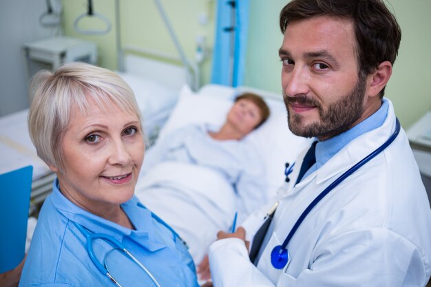 Retrato de médico e enfermeiro em pé no quarto de hospital