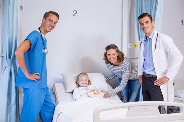 Retrato de médicos, paciente e mulher no quarto do hospital