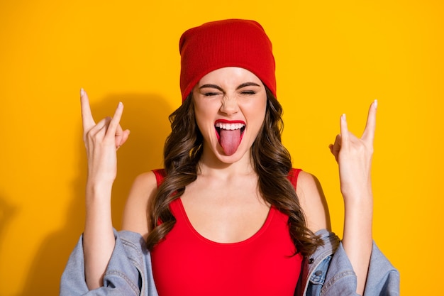 Retrato de menina adolescente curtindo show punk fazendo símbolo com chifres dedos mostrarem a língua