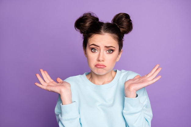 Retrato de menina adolescente desapontada e inconsciente sem resposta escolha difícil decisão solução encolher de ombros ombro vestir roupa de boa aparência isolada sobre fundo de cor roxa