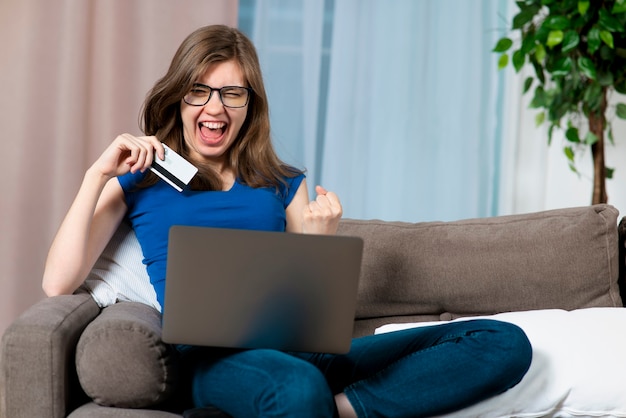 Retrato de menina adolescente feliz e animada, jovem alegre e bem-sucedida se divertindo com o crédito