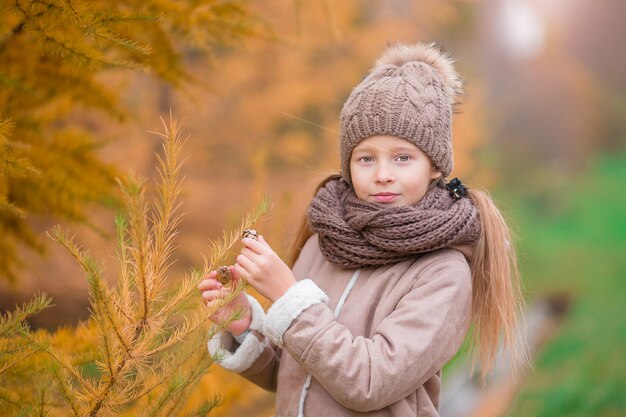 Retrato de menina adorável ao ar livre no lindo dia de outono