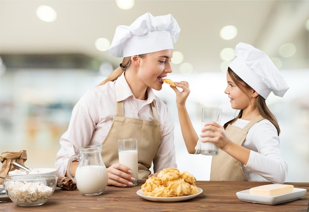 Retrato de menina adorável e sua mãe com biscoitos