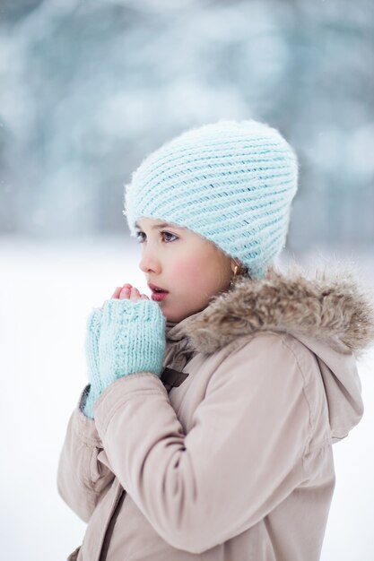 Retrato de menina aquece suas mãos no inverno