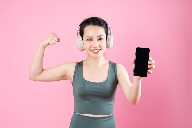 Retrato de menina asiática fitness, isolado em fundo rosa