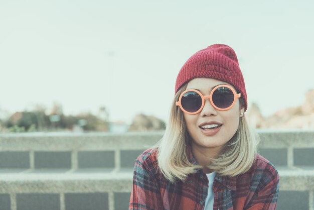 Retrato de menina asiática hipster usa óculos de sol laranja estilo vintage estilo de vida de mulher jovem e jovem conceito de estilo indy