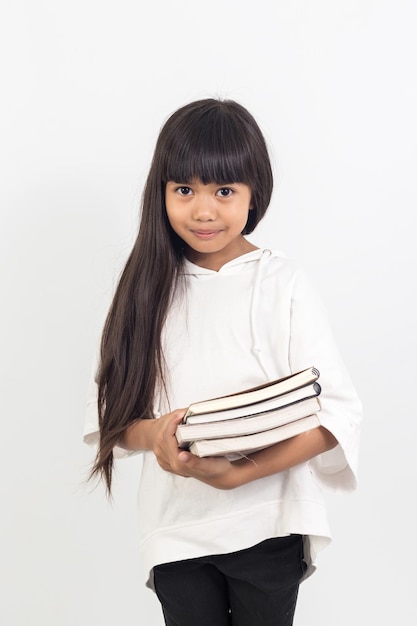 Retrato de menina asiática segurando um livro sobre fundo branco
