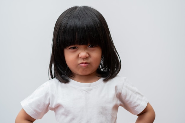 Retrato de menina asiática zangada e triste em fundo branco isolado a emoção de uma criança