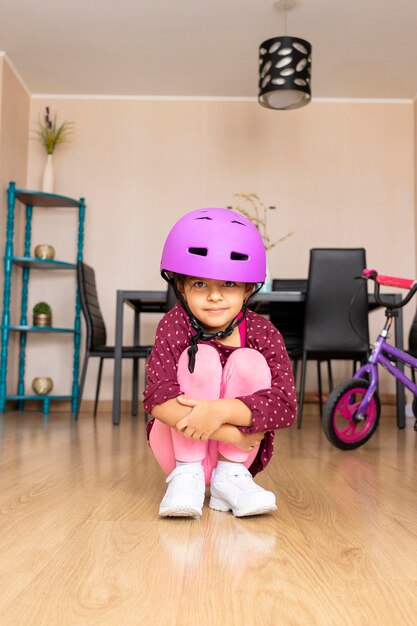 Foto retrato de menina bonita com brinquedo sentado no chão em casa