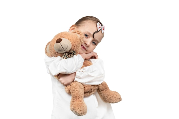 Retrato de menina bonita com corte de cabelo elegante em abraçar com ursinho de brinquedo isolado no fundo branco