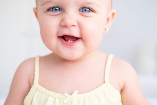 retrato de menina bonitinha sorrindo com os primeiros dentes de leite. criança recém-nascida saudável