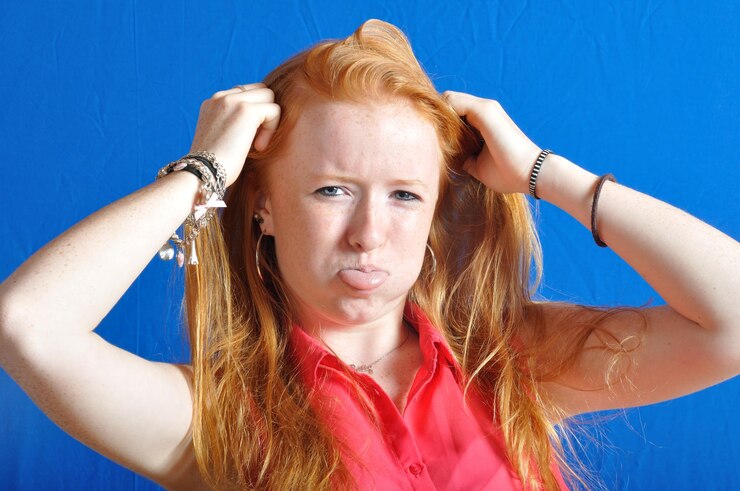 Foto retrato de menina com a mão no cabelo sobre fundo azul