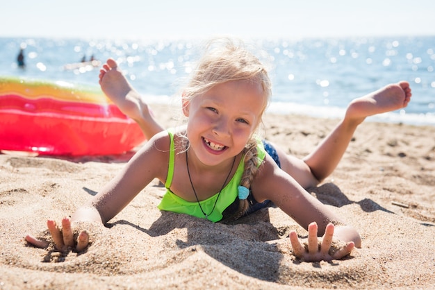 Retrato de menina com círculo de borracha inflável na praia