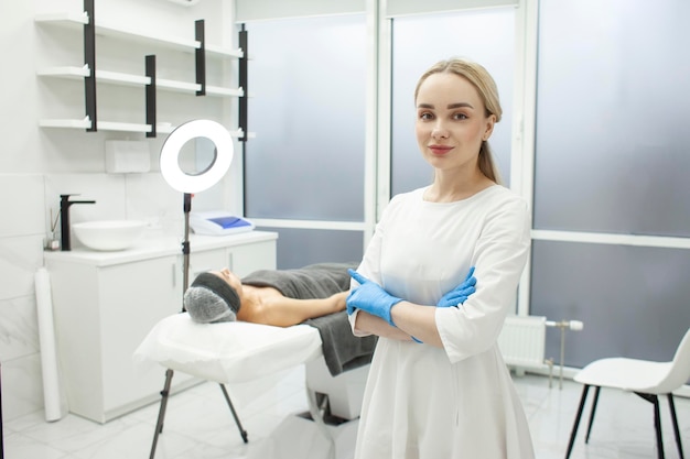 Retrato de menina cosmetologista na clínica de cosmetologia jovem médico dermatologista de uniforme