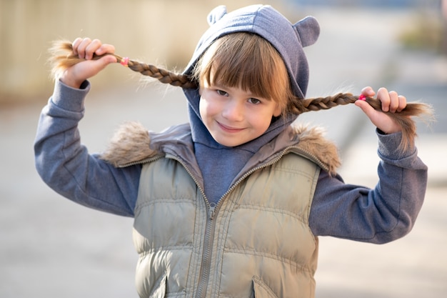 Retrato de menina criança feliz com tranças de cabelo.