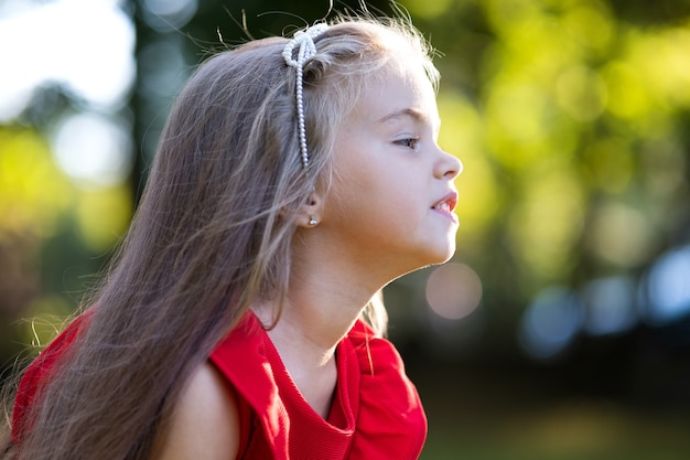 Foto retrato de menina criança linda feliz ao ar livre, aproveitando o dia quente e ensolarado de verão.