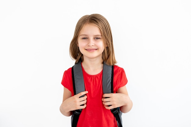 Retrato de menina da escola primária com mochila isolada no fundo branco